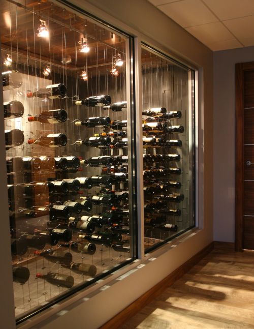 Modern wine racks from Cable Wine Systems create an illusion of floating bottles. modern wine cellar design with Glass Walls and Cable Wine Racks