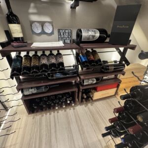 6- Even the smallest wine cellars deserve beautiful displays. This small wine cellar setup features angled wooden racks, collectible crates, and label-forward organization for easy viewing.